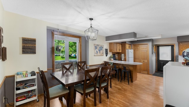 401 Main St, Osakis, MN 56360 - dining area with light wood finished floors, a textured ceiling, and a chandelier