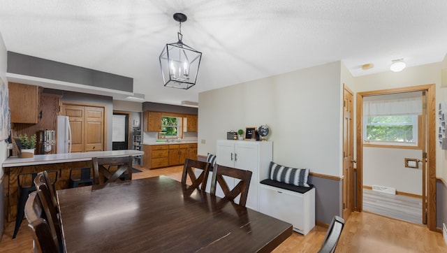 401 Main St, Osakis, MN 56360 - dining room with light wood-style floors, plenty of natural light, a chandelier, and baseboards