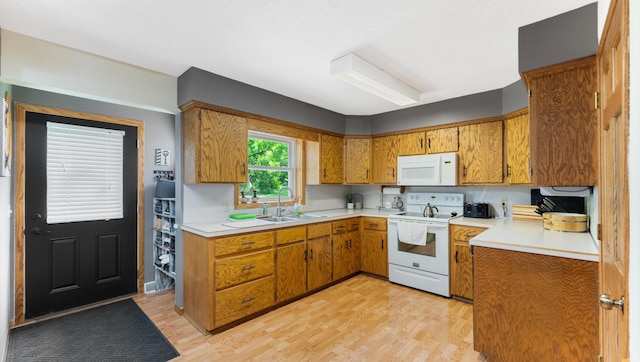 401 Main St, Osakis, MN 56360 - kitchen featuring white appliances, a sink, light countertops, brown cabinetry, and light wood-type flooring
