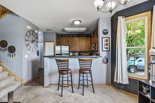 15359 Foliage Ave Unit 501, Apple Valley, MN 55124 - kitchen with stainless steel appliances, light colored carpet, a kitchen breakfast bar, a chandelier, and a textured ceiling