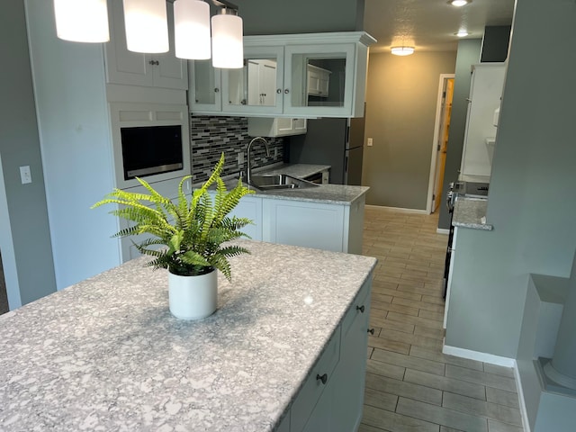 6563 Parkview Cir, Baxter, MN 56425 - kitchen featuring a sink, backsplash, white cabinetry, and baseboards