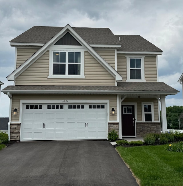 5022 Useppa Trl, Woodbury, MN 55129 - view of front of home with stone siding, driveway, a garage, and roof with shingles