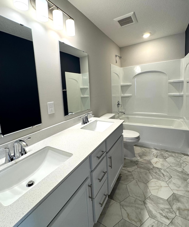 5022 Useppa Trl, Woodbury, MN 55129 - full bath with double vanity, toilet, marble look tiles, tub / shower combination, and a textured ceiling