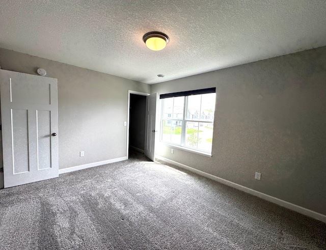 5022 Useppa Trl, Woodbury, MN 55129 - unfurnished bedroom featuring baseboards, carpet flooring, and a textured ceiling