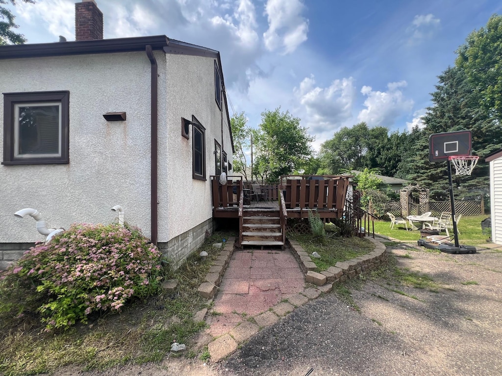 4121 2nd St NE, Columbia Heights, MN 55421 - view of property exterior with a chimney, a deck, and stucco siding