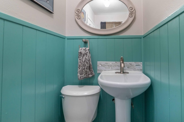 327 Channing Ave, Fergus Falls, MN 56537 - half bath featuring toilet, a decorative wall, and a wainscoted wall