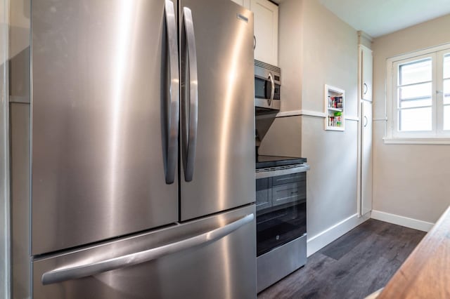 327 Channing Ave, Fergus Falls, MN 56537 - kitchen with stainless steel appliances, white cabinets, dark wood-style floors, and baseboards