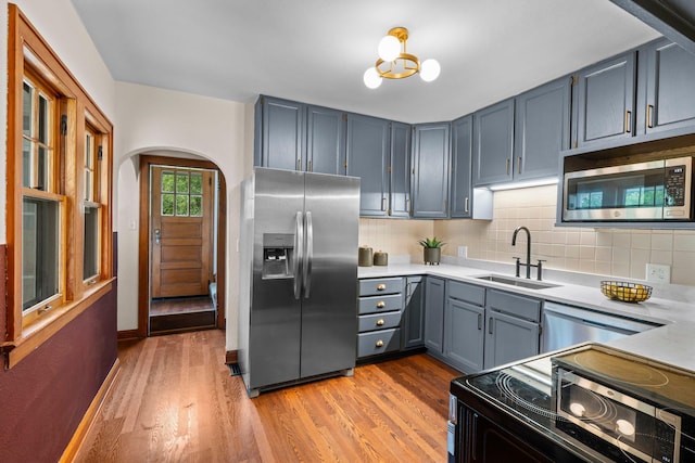 3017 32nd Ave NE, Saint Anthony, MN 55418 - kitchen featuring appliances with stainless steel finishes, arched walkways, light countertops, and tasteful backsplash