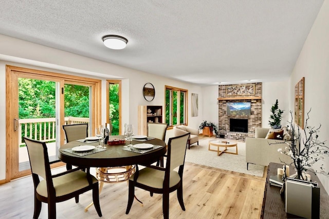 7158 Deerwood Ln N, Maple Grove, MN 55369 - dining room with light wood-type flooring and a brick fireplace