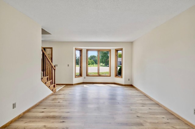 7158 Deerwood Ln N, Maple Grove, MN 55369 - empty room featuring light wood-style floors and stairs