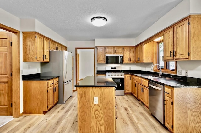 7158 Deerwood Ln N, Maple Grove, MN 55369 - kitchen with stainless steel appliances, light wood finished floors, a center island, dark countertops, and a textured ceiling