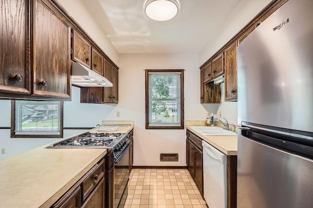 10465 Osage St NW, Coon Rapids, MN 55433 - kitchen with freestanding refrigerator, gas stove, white dishwasher, under cabinet range hood, and light countertops