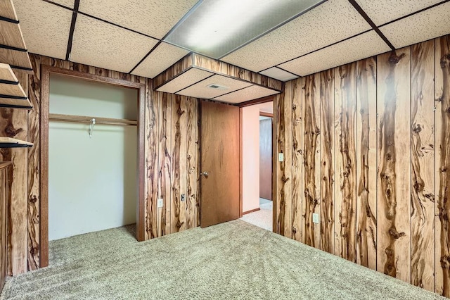 10465 Osage St NW, Coon Rapids, MN 55433 - unfurnished bedroom featuring a drop ceiling, wooden walls, carpet floors, and a closet