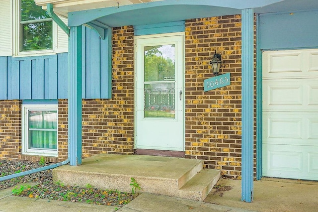 10465 Osage St NW, Coon Rapids, MN 55433 - property entrance with brick siding, board and batten siding, and a garage