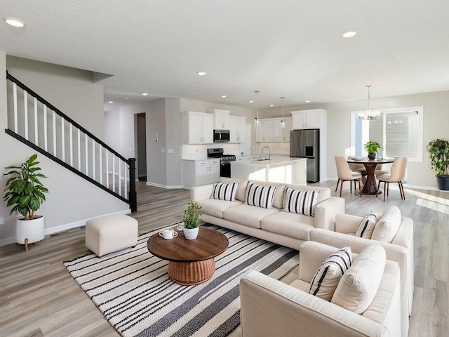 3235 Jandura Ave NE, Saint Michael, MN 55376 - living room featuring stairs, light wood-style flooring, a chandelier, and recessed lighting