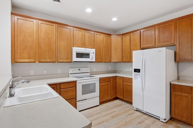10612 172nd Ln NW, Elk River, MN 55330 - kitchen featuring white appliances, a sink, recessed lighting, light wood-type flooring, and brown cabinets