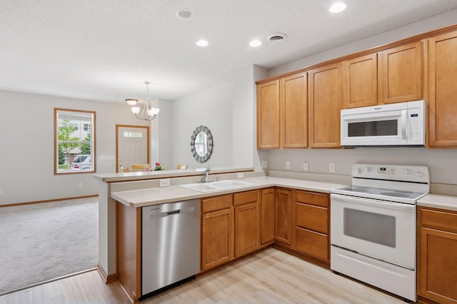 10612 172nd Ln NW, Elk River, MN 55330 - kitchen with white appliances, a sink, a peninsula, light wood-style flooring, and a chandelier