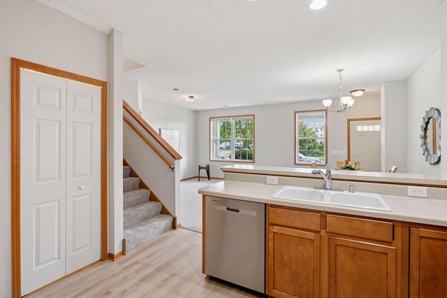 10612 172nd Ln NW, Elk River, MN 55330 - kitchen featuring stainless steel dishwasher, a sink, brown cabinetry, light wood finished floors, and light countertops