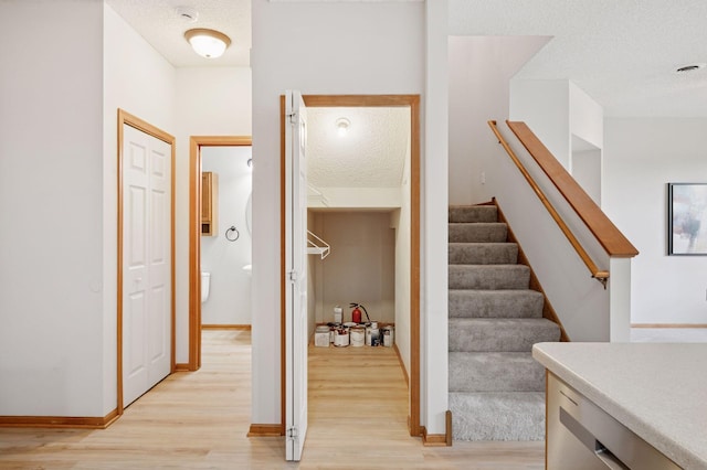 10612 172nd Ln NW, Elk River, MN 55330 - stairs featuring wood finished floors, a textured ceiling, and baseboards