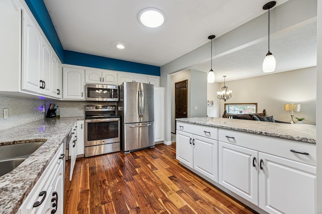 11788 65th Pl N, Maple Grove, MN 55369 - kitchen with appliances with stainless steel finishes, dark wood-style flooring, white cabinets, light stone countertops, and a chandelier