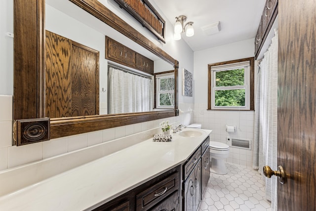 11788 65th Pl N, Maple Grove, MN 55369 - full bathroom featuring vanity, toilet, tile patterned floors, tile walls, and wainscoting