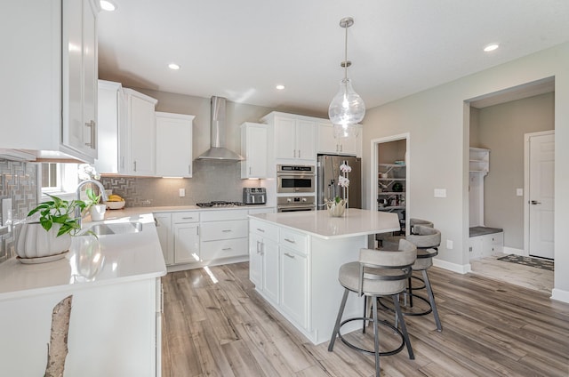 6016 Inskip Ave S, Cottage Grove, MN 55016 - kitchen featuring wall chimney range hood, a sink, stainless steel appliances, light wood-style flooring, and recessed lighting