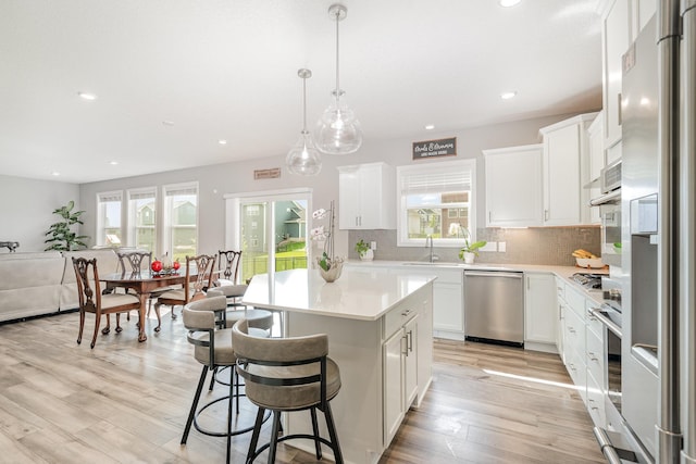 6016 Inskip Ave S, Cottage Grove, MN 55016 - kitchen featuring appliances with stainless steel finishes, a sink, light countertops, decorative backsplash, and recessed lighting