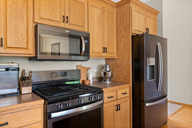 2554 160th Ave NE, Ham Lake, MN 55304 - kitchen featuring appliances with stainless steel finishes, dark countertops, and light wood-style flooring