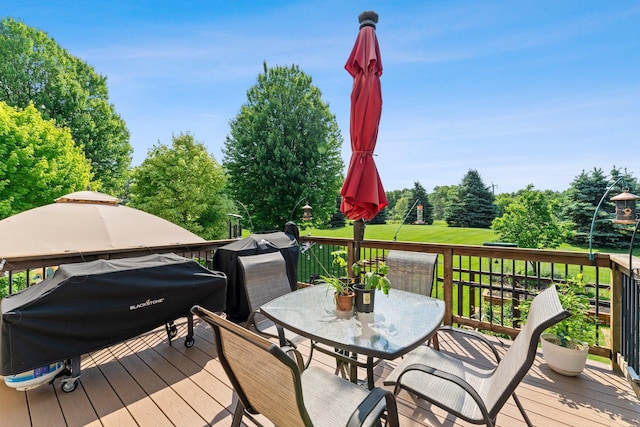 2554 160th Ave NE, Ham Lake, MN 55304 - wooden deck with outdoor dining space, a grill, and view of wooded area