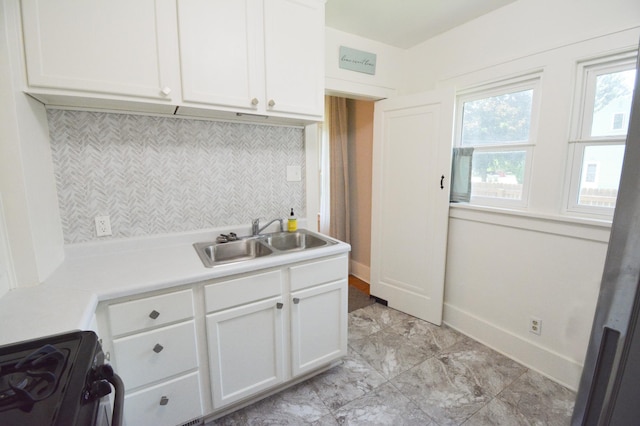 1331 1st St SE, Rochester, MN 55904 - kitchen featuring a sink, range with gas stovetop, white cabinets, backsplash, and light countertops