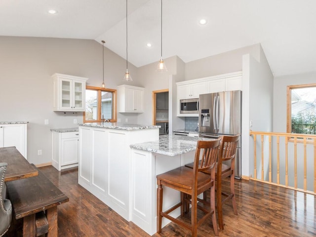 16850 Willowwood Cir SE, Prior Lake, MN 55372 - kitchen with stainless steel appliances, vaulted ceiling, a center island, dark wood-style floors, and glass insert cabinets