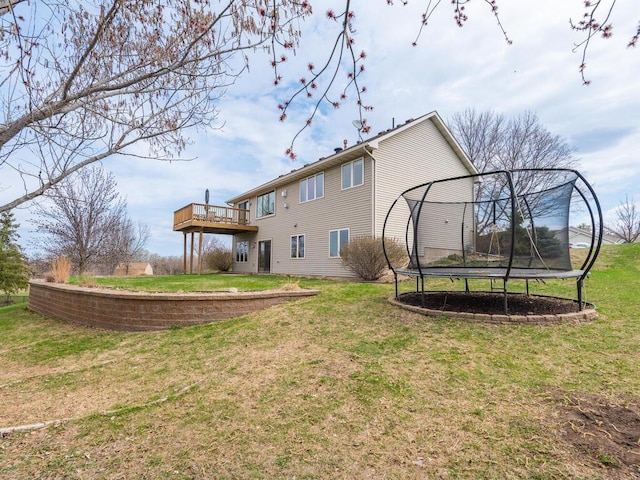 16850 Willowwood Cir SE, Prior Lake, MN 55372 - back of house featuring a trampoline, a yard, and a wooden deck