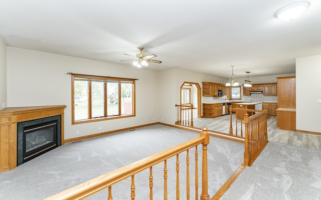 2310 Wilshire Ln NE, Rochester, MN 55906 - unfurnished living room featuring baseboards, plenty of natural light, and light colored carpet