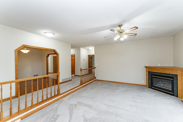 2310 Wilshire Ln NE, Rochester, MN 55906 - unfurnished living room featuring carpet flooring, a tiled fireplace, baseboards, and a ceiling fan
