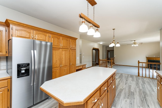 2310 Wilshire Ln NE, Rochester, MN 55906 - kitchen with stainless steel refrigerator with ice dispenser, light countertops, ceiling fan, a kitchen island, and brown cabinets
