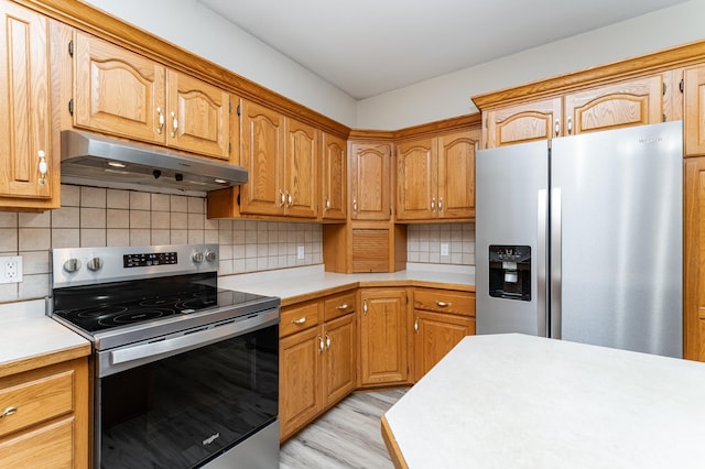 2310 Wilshire Ln NE, Rochester, MN 55906 - kitchen featuring stainless steel appliances, under cabinet range hood, light countertops, light wood-style floors, and decorative backsplash