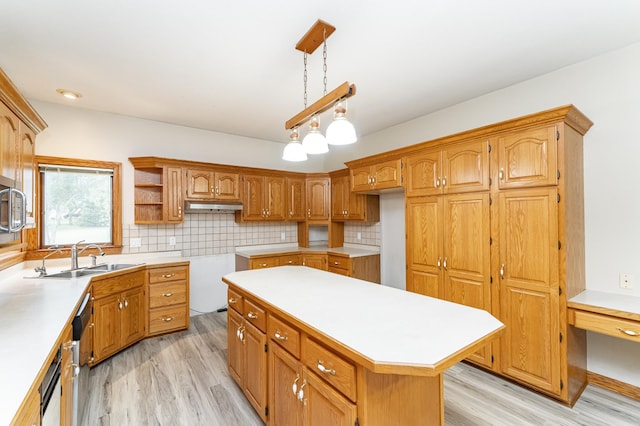 2310 Wilshire Ln NE, Rochester, MN 55906 - kitchen with a sink, light wood finished floors, under cabinet range hood, decorative backsplash, and brown cabinetry