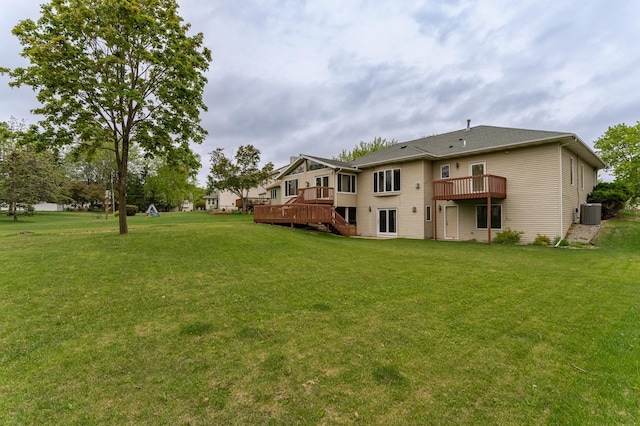 2310 Wilshire Ln NE, Rochester, MN 55906 - back of house featuring a wooden deck, a lawn, and central AC
