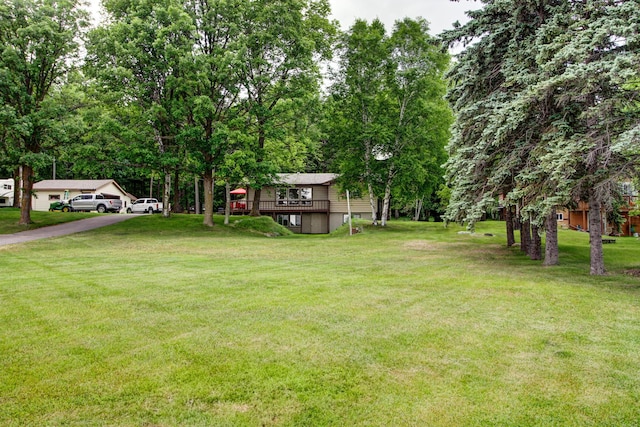 14070 County 18, Park Rapids, MN 56470 - view of green lawn with asphalt driveway and a deck