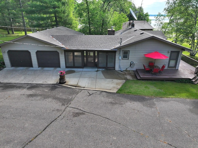 14070 County 18, Park Rapids, MN 56470 - view of front facade featuring concrete driveway, a garage, roof with shingles, and a wooden deck