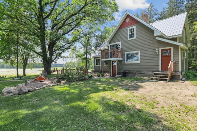 35301 Lily St NW, Springvale Twp, MN 55008 - back of house with a chimney, entry steps, a yard, and metal roof
