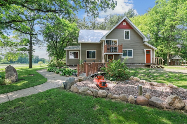 35301 Lily St NW, Springvale Twp, MN 55008 - view of front of property featuring a front lawn, metal roof, a balcony, and a wooden deck