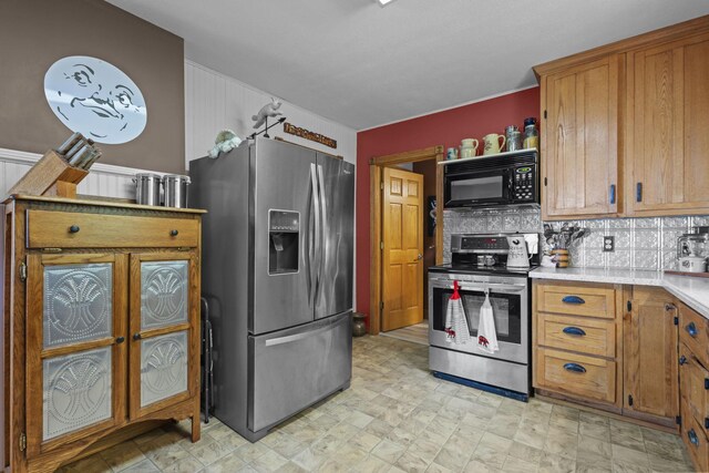 35301 Lily St NW, Springvale Twp, MN 55008 - kitchen with appliances with stainless steel finishes, light countertops, brown cabinetry, and backsplash