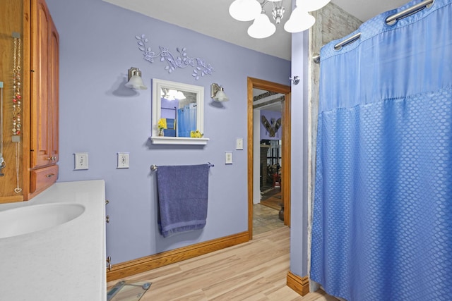 35301 Lily St NW, Springvale Twp, MN 55008 - bathroom featuring a chandelier, wood finished floors, vanity, and a shower with curtain