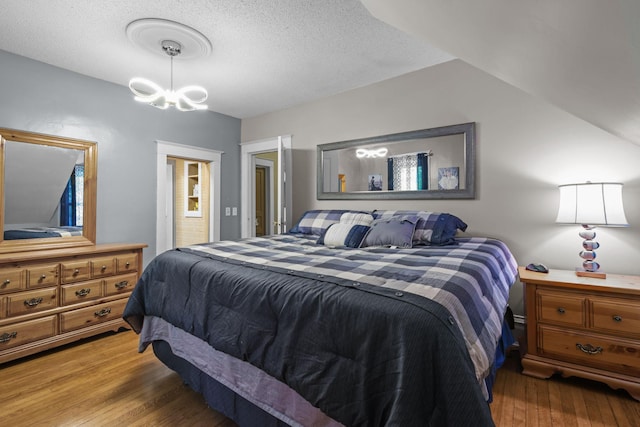 35301 Lily St NW, Springvale Twp, MN 55008 - bedroom with wood finished floors, a chandelier, and a textured ceiling