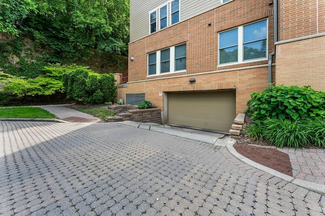 620 Main St N Unit 412, Stillwater, MN 55082 - view of property exterior featuring a garage, brick siding, and driveway