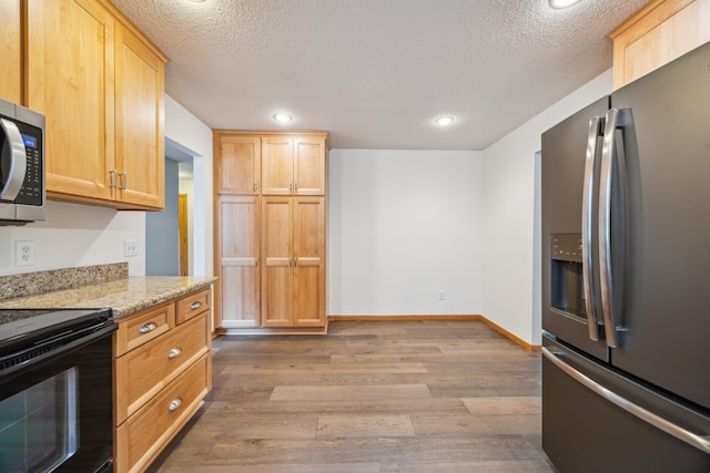 7813 111th St, Bloomington, MN 55438 - kitchen with stainless steel appliances, dark wood-style flooring, light stone counters, a textured ceiling, and light brown cabinets