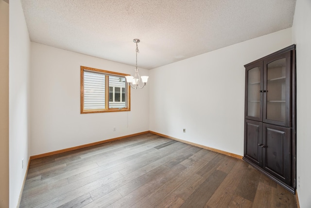 7813 111th St, Bloomington, MN 55438 - spare room with dark wood finished floors, a chandelier, and a textured ceiling