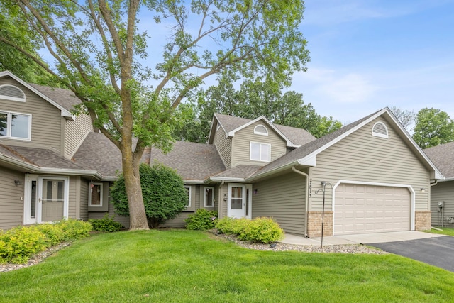 7813 111th St, Bloomington, MN 55438 - traditional home featuring a shingled roof, an attached garage, asphalt driveway, brick siding, and a front yard
