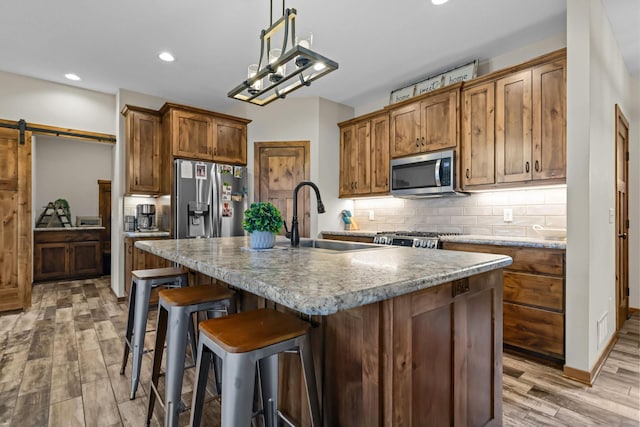 5855 281st Ave NW, Spencer Brook Twp, MN 55040 - kitchen with stainless steel appliances, light wood-type flooring, backsplash, recessed lighting, and brown cabinetry